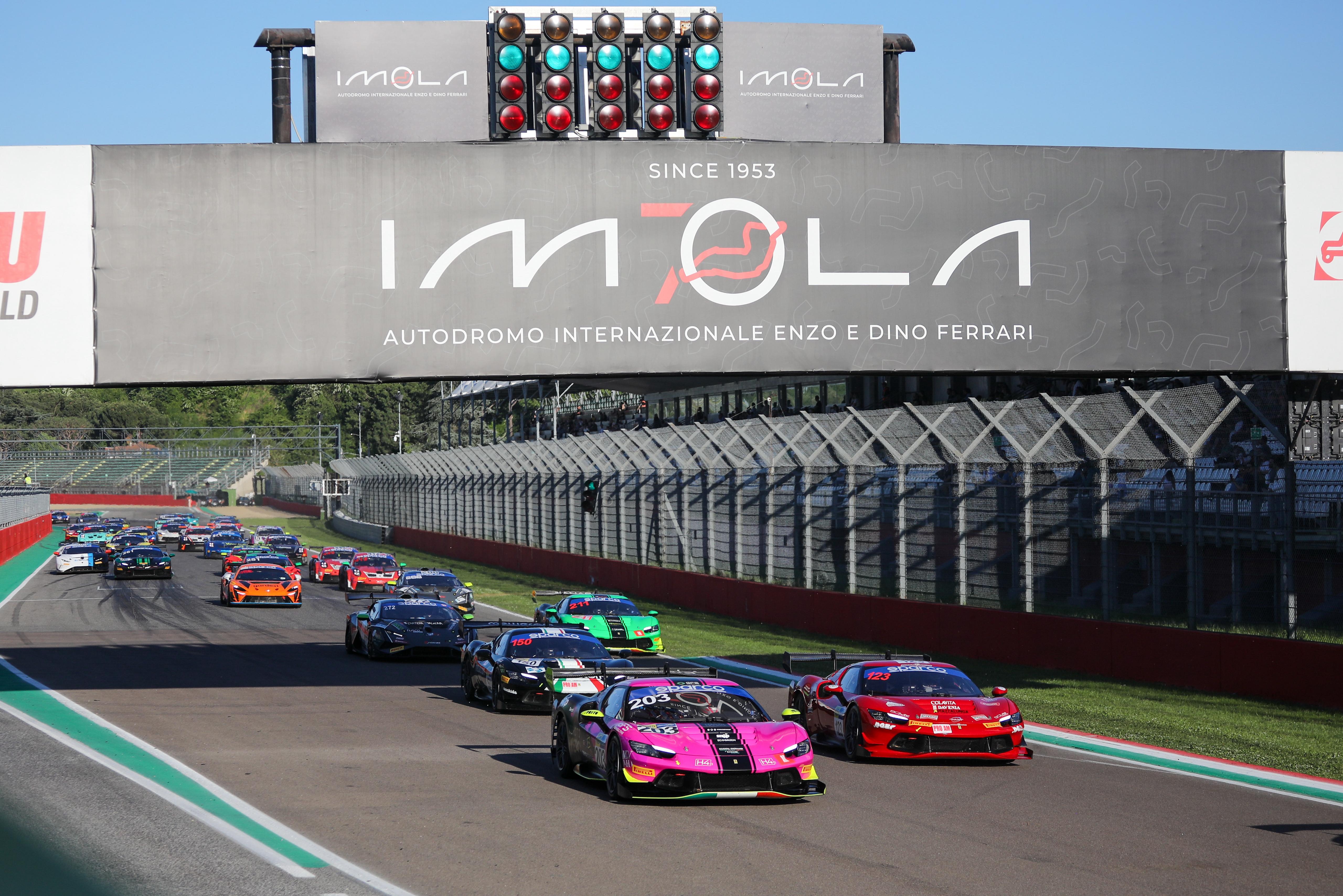 Train of Ferrari race cars on track